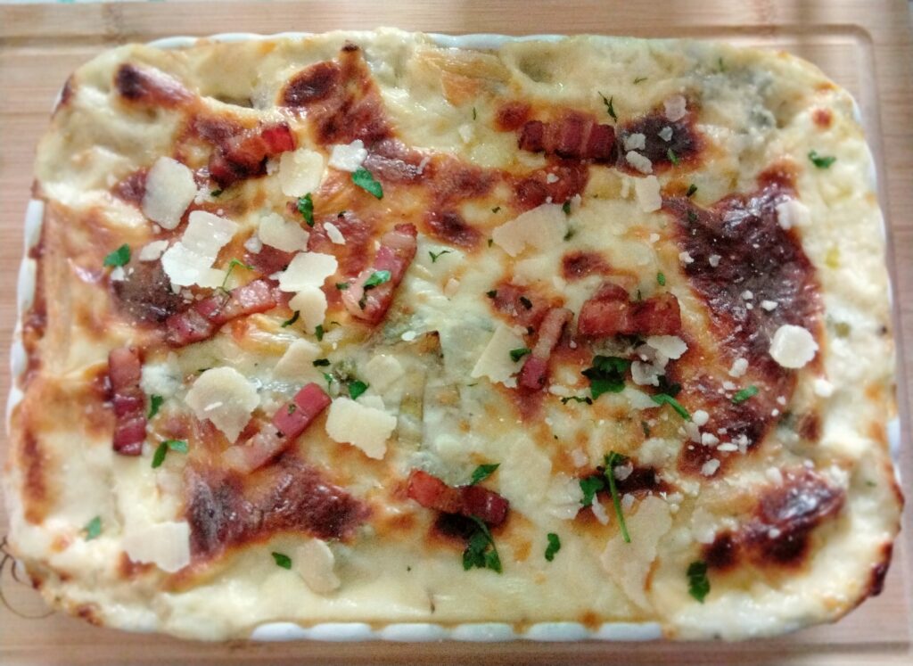 Pasta al forno in bianco con carciofi  piselli e pancetta