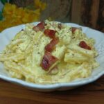 Pasta con crema di ricotta allo zafferano e pancetta croccante.